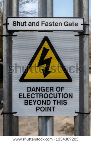 Shut and fasten gate danger of electrocution beyond this point sign on a railway access gate in the United Kingdom