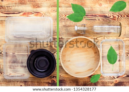 Plastic and natural dishes on wooden background