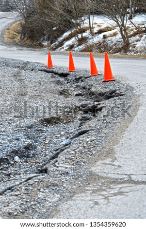 Orange Pylons Warning of Washed Away Road in Winter
