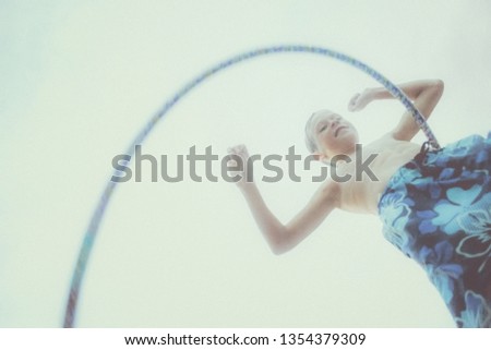Vintage style image of a smiling boy dancing with a hoop, retro noise added