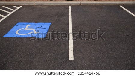 Disabled parking bay next to an ordinary parking bay in a car park.