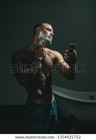 Shaving cream. Barber scissors and straight razor. Ideas about Barbershop and Barber salon. Vintage barber shop shaving. Hairdresser makes hairstyle a man with a beard
