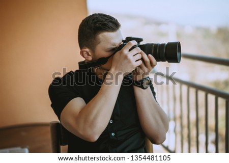 Handsome young photographer sitting on chair