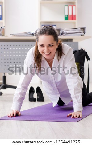 Female employee doing sport exercises in the office 