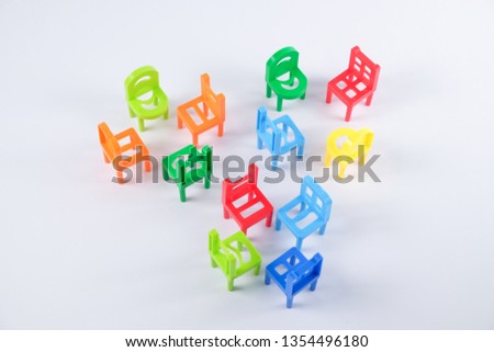 Colourful toy chairs arranged in small groups isolated on white background