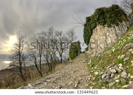 Ancient fortifications in the mountains in the rays of sunset. Genoese fortress
