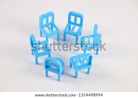 Toy chair being arranged in a group with concept signify leadership isolated on white background.