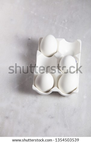 eggs in beautiful packaging on a marble background. Easter concept with copy space