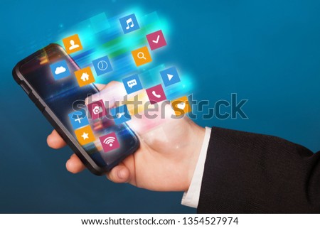 Hand using phone with colorful fast moving application icons and symbols concept