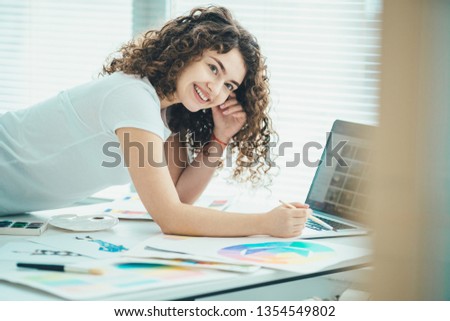 The happy woman working with a brush and a laptop