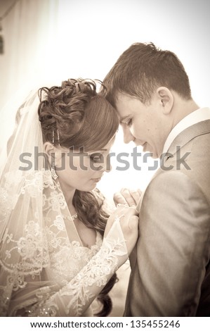 bride dresses groom boutonniere. bride fixing boutonniere of groom. Bride arranging boutonniere flower on suit jacke groom.