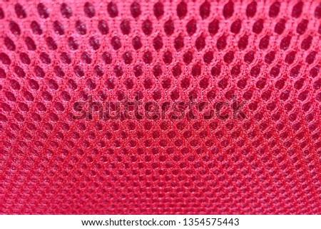 Red fabric background, intricately woven textiles pattern.