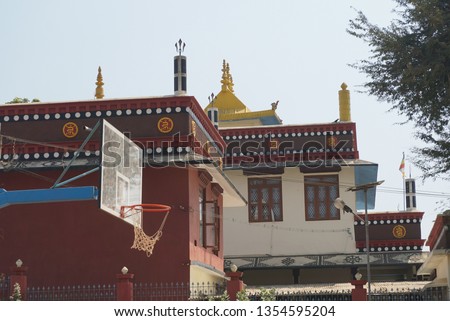 a red and white tibetan monastery and a basketball backboard