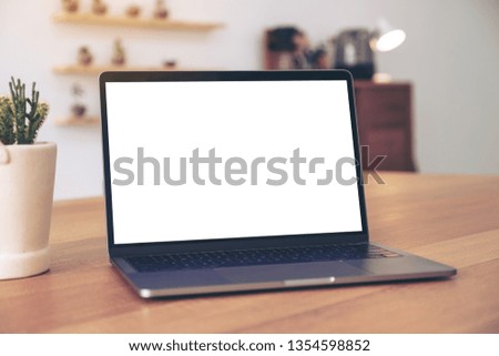 Mockup image of laptop with blank white desktop screen on wooden table 