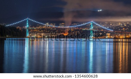 Vancouver, British Columbia. Canada Long exposure from below of the Lions Gate Bridge with lights trail, glitters and clouds.