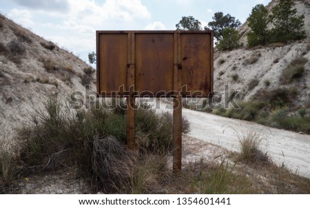 Rusty brown sign on a mountain dirt road