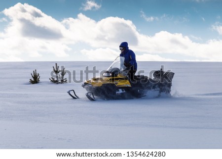 Woman on a snowmobile moving in the winter forest in the mountains of the Southern Urals.