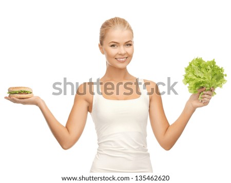 picture of sporty woman with green lettuce and hamburger