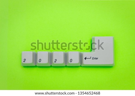 Computer keyboard keys with 2020 enter written using the white buttons on green background. New year technology concept. New year 2020 card with copyspace.