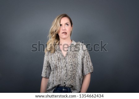 Beautiful young blonde woman in modern outfit being nervous and scared biting lips looking camera with impatient expression, pensive 
