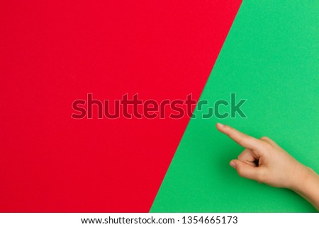 Hand pointing a finger on green and red color background