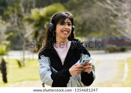 Attractive young woman enjoying her time outside in park. play m