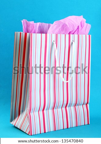 Striped shopping bag on blue background