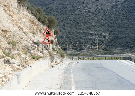 Empty asphalt road in the Troodos mountains, Cyprus with two warning signs