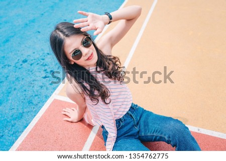 Woman hipster tourist is traveling at colorful basketball court in Choi Hung Estate for holiday vacation.