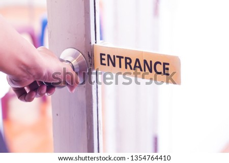 The man opens the door. Close - up of hand and door handle.bright light through glass concept of change.entrance signage
