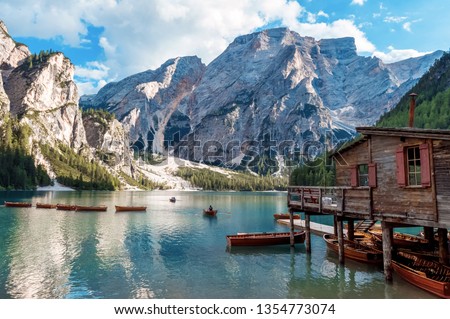 Lake Lago di Braies in Dolomiti mountains, South Tyrol, Italy. Dock with romantic old wooden rowing boats on lake. Amazing view of Lago di Braies (Braies lake, Pragser wildsee) in sunset light. Royalty-Free Stock Photo #1354773074