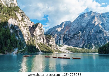 Lake Lago di Braies in Dolomiti mountains, South Tyrol, Italy. Dock with romantic old wooden rowing boats on lake. Amazing view of Lago di Braies (Braies lake, Pragser wildsee) in sunset light. Royalty-Free Stock Photo #1354773086