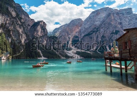 Lake Lago di Braies in Dolomiti mountains, South Tyrol, Italy. Dock with romantic old wooden rowing boats on lake. Amazing view of Lago di Braies (Braies lake, Pragser wildsee) in sunset light. Royalty-Free Stock Photo #1354773089