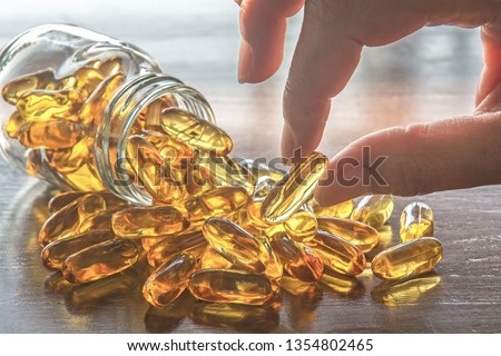 Fish oil, omega 3 with vitamin D capsules good for heart health on a white backguound, healthy diet concept.