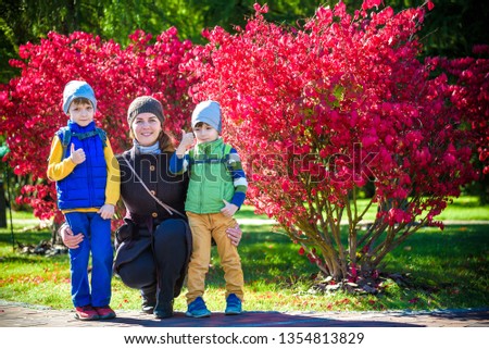 Picture of young mother hugging two little children, closeup portrait of happy family, cute brunette female with two son outdoor in spring time, smiling faces, happiness and love concept
