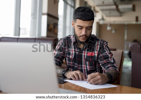 Businessman working writing documents in a cafe signing contract