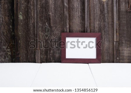 brown painted picture frame, white table, old wooden wall
