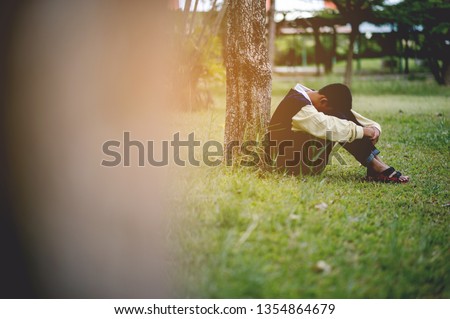 Picture of a young boy sitting sadly alone in the forest Depression concept