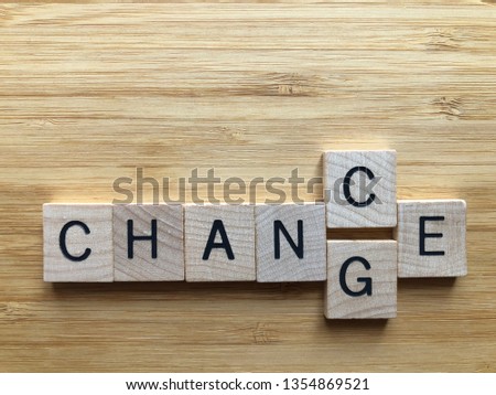 Wood alphabet letters spelling out the words Chance or Change with an interchangeable C and G, isolated on a wood background with copy space