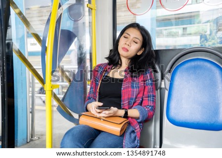 Picture of a female passenger falling asleep during sitting on the bus seat