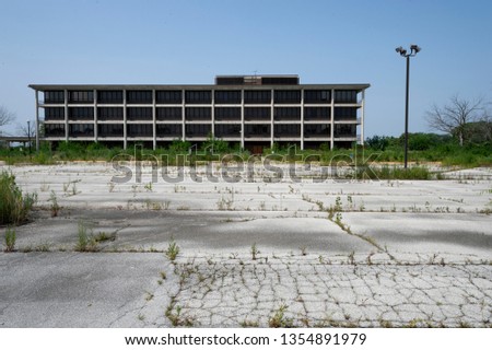 Empty overgrown parking lot and abandoned  former hospital building  Tinley Park Illinois Royalty-Free Stock Photo #1354891979
