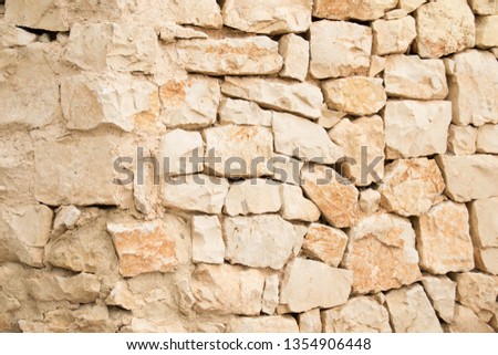 It is an exterior wall of stone factory, part placed in dry, part placed with mortar.