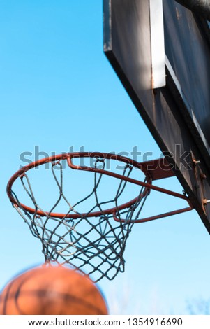 Outdoor competitions on basketball. The basketball got to a basket. At a background the blue sky