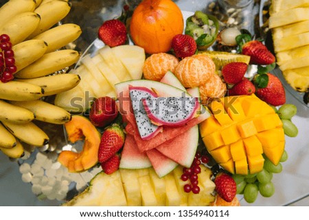 Fresh organic fruits background. Healthy eating concept. Fresh, exotic, organic fruits, light snacks in a plate on a buffet table.