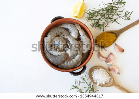 Raw shrimps and spices on white background.