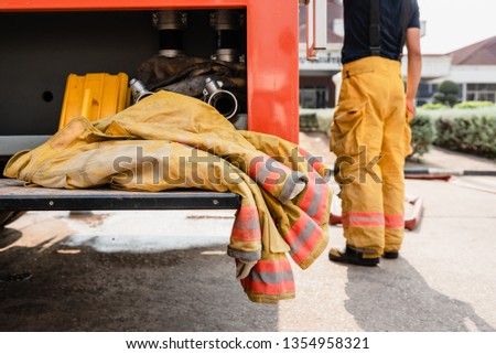 Firefighter protection suit on fire truck.Rescue clothes on the rescue car.Firemen gear on firetruck.Fire fighting training. 
