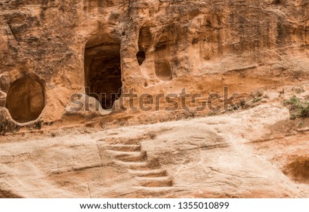 cave and stairs carved in rocky yellow sand stone inside natural canyon 