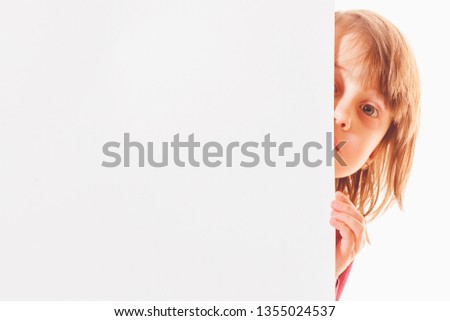 Little cute child girl showing from blank white board. Free space for text.