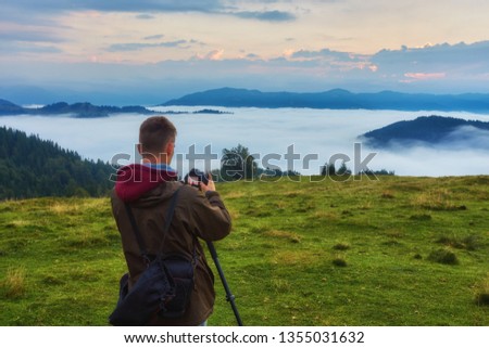 Travel photographer man taking sunrise dawn nature of mountain landscape. Hiker tourist professional photographer on adventure vacation shooting camera on tripod