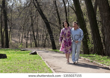 Elderly couple walking in the park in spring. Happy aged couple walking in blossom park.